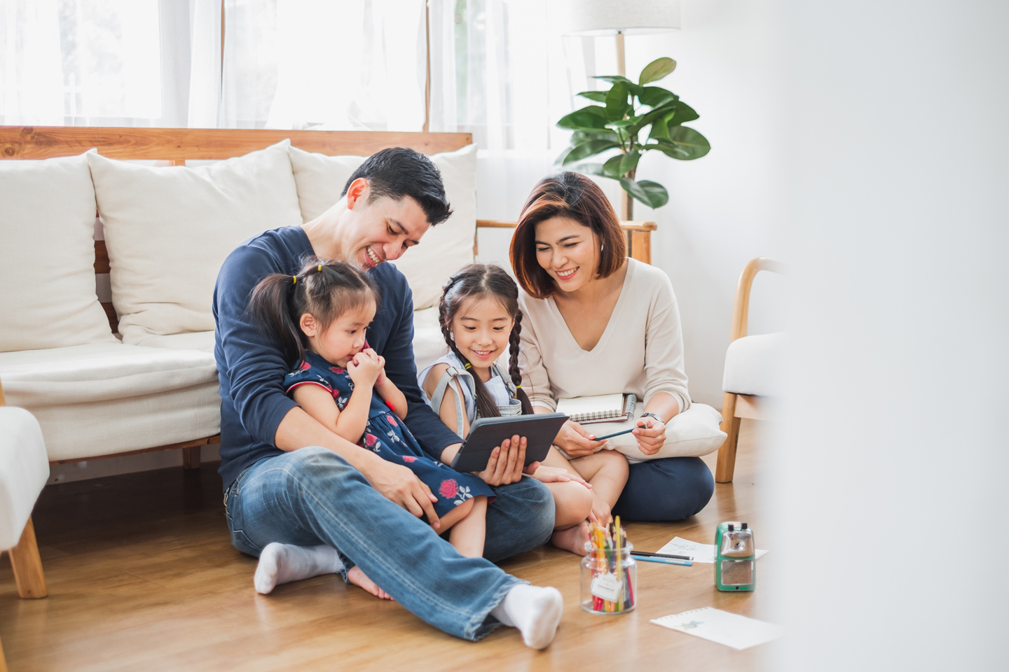 Parents looking at tablet with children