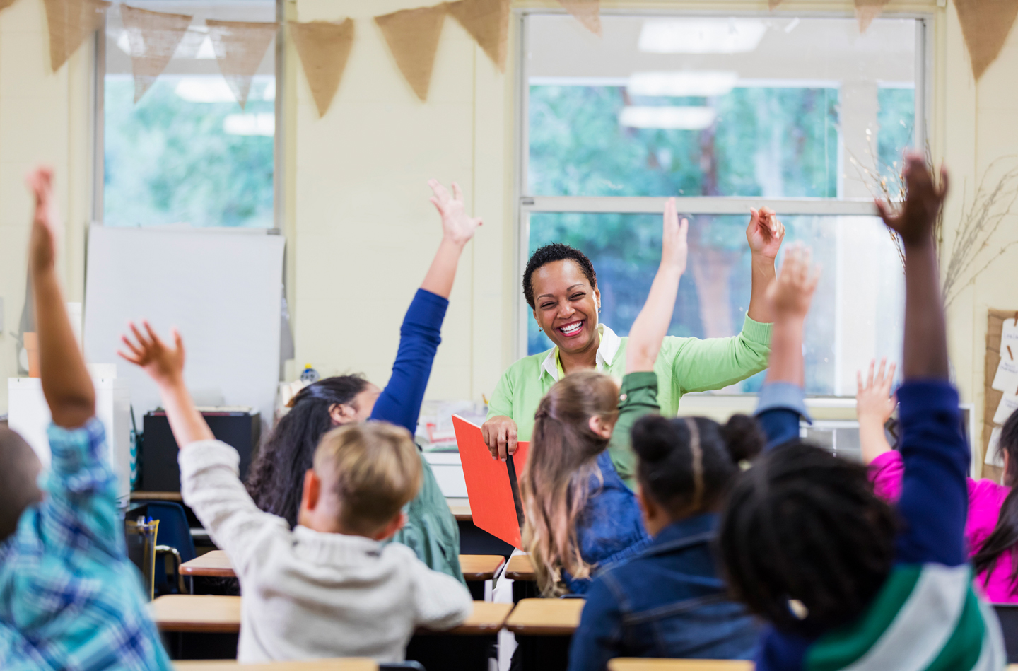 Children with hands up in class