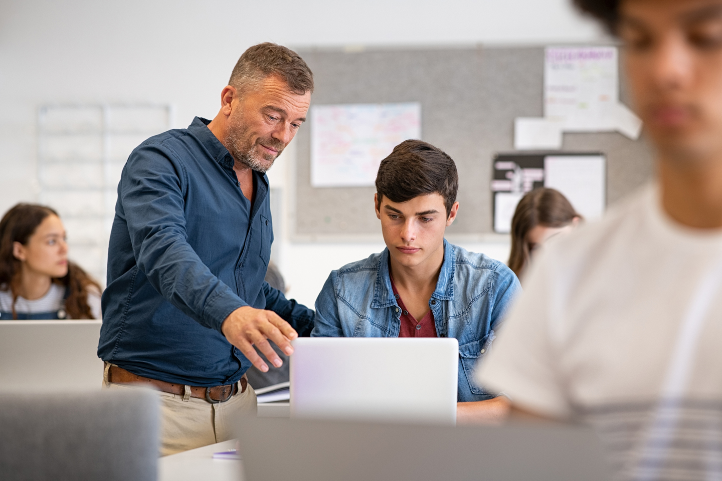 Student and teacher looking at laptop