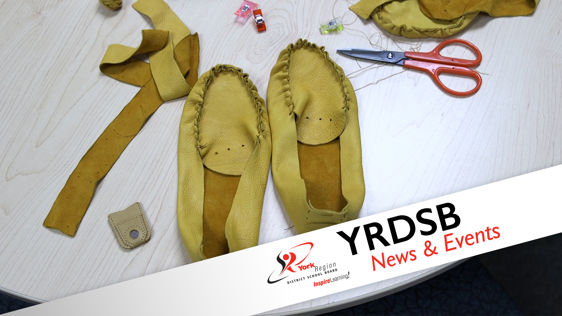 Almost finished moccasins on table with pair of scissors