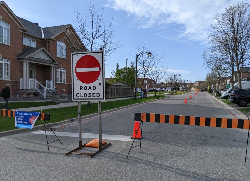 Residential road, with barrier across road and road closed sign
