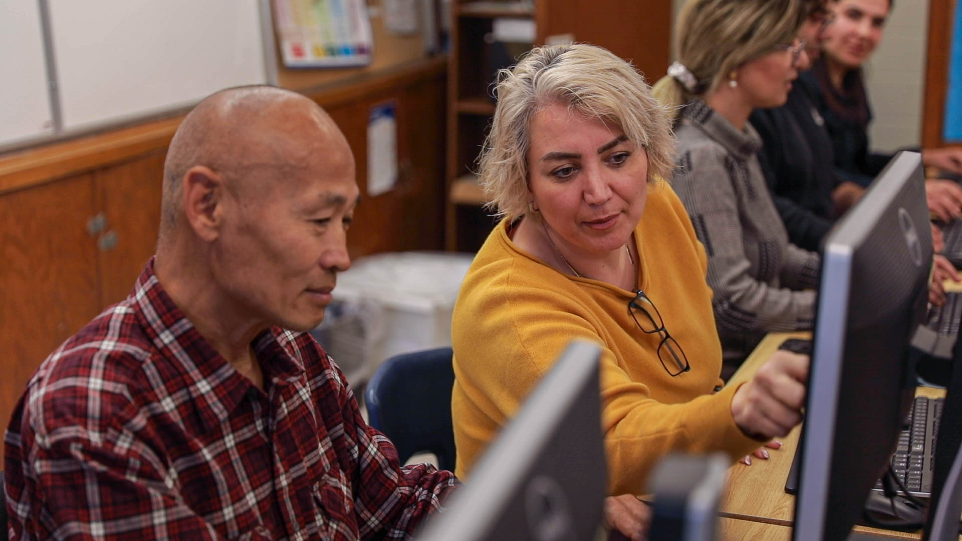 Adult learners working in a computer lab.