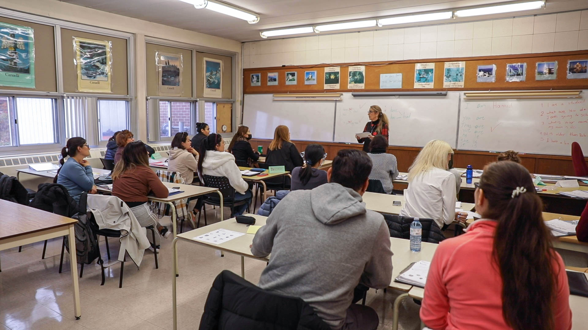 Adult learners in class, observing their language instructor.