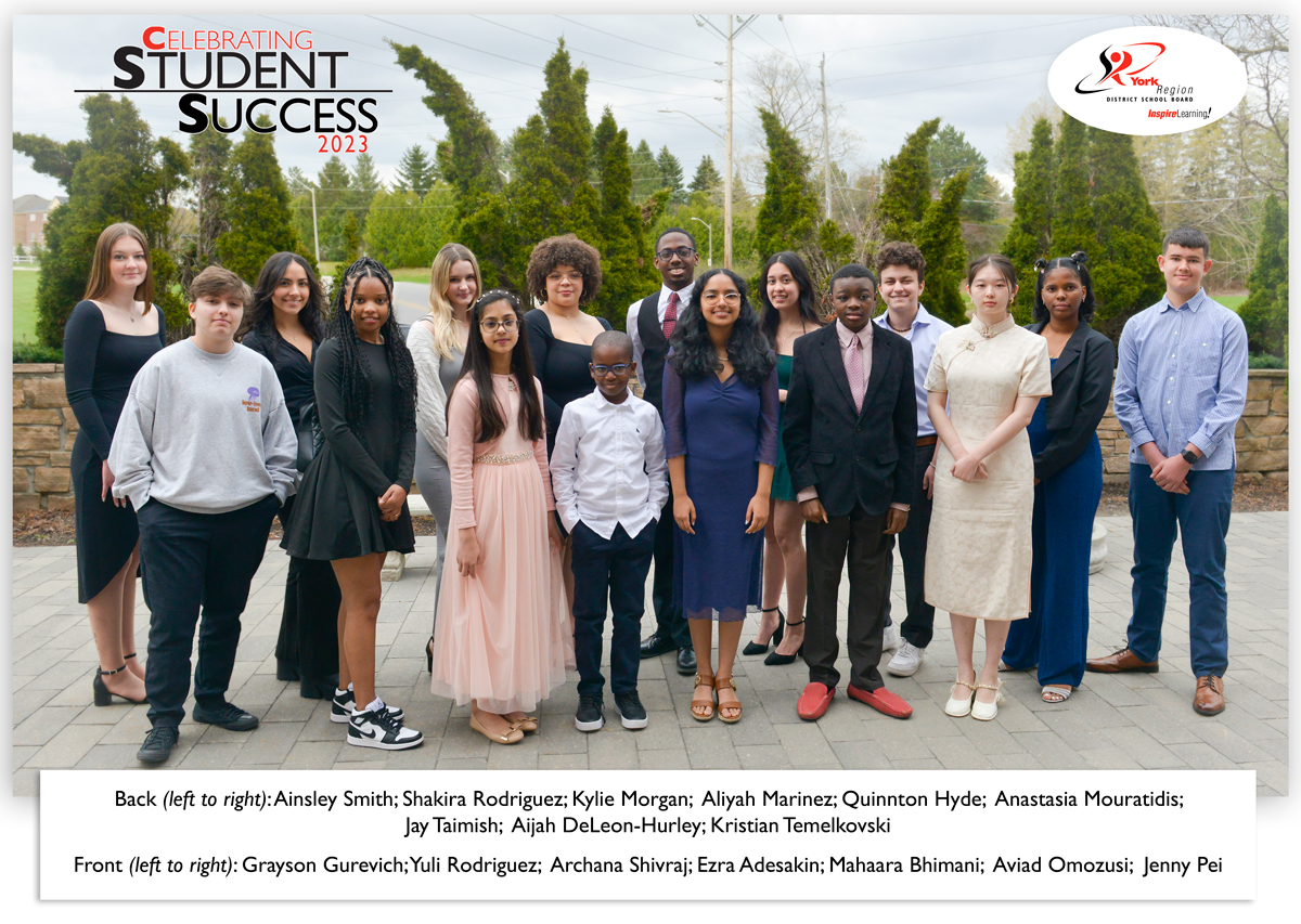 Student award recipients standing outside in a group with a backdrop of tall shrubs. Their names are listed beneath the photo.