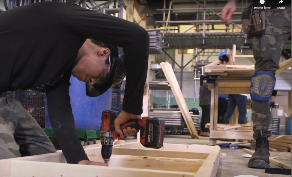 Student drilling into wooden frame