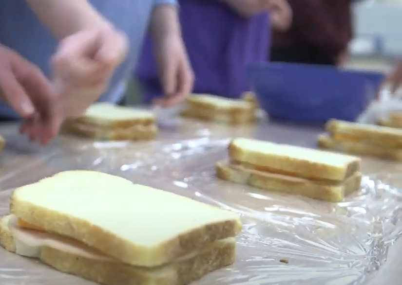 Hands prepare sandwiches