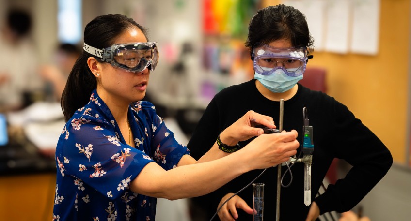 Teacher holds test tube while student observes