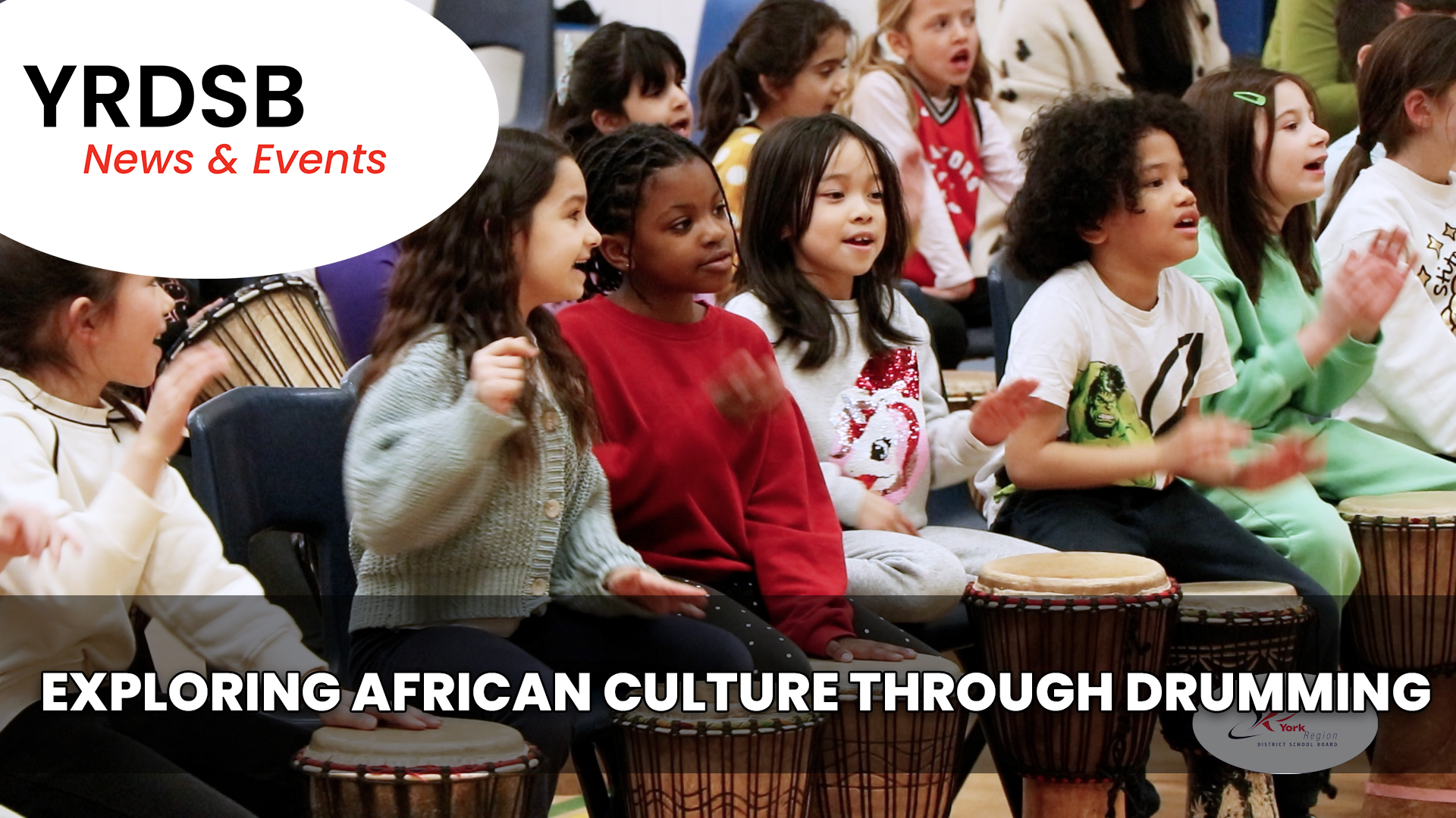 Students sitting on the floor drumming