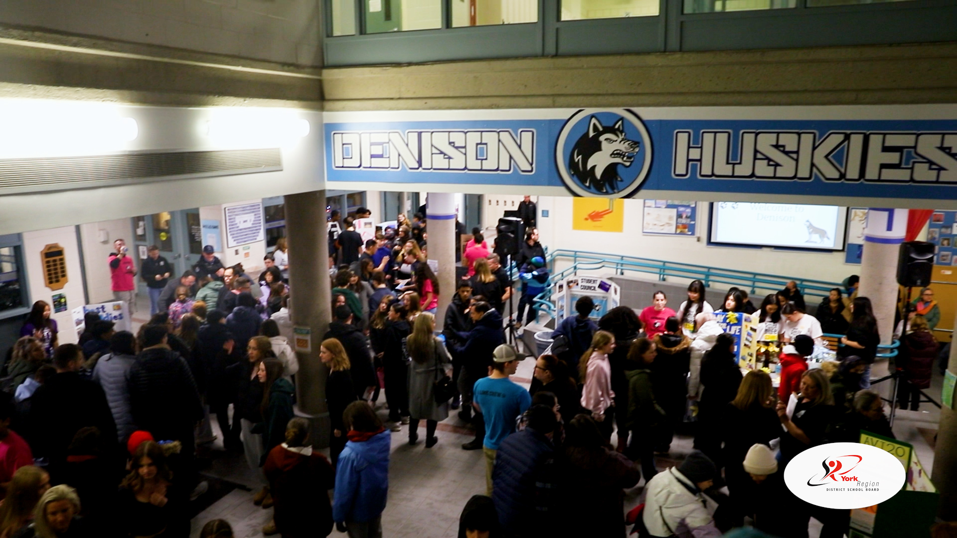 Crowd of people in school foyer