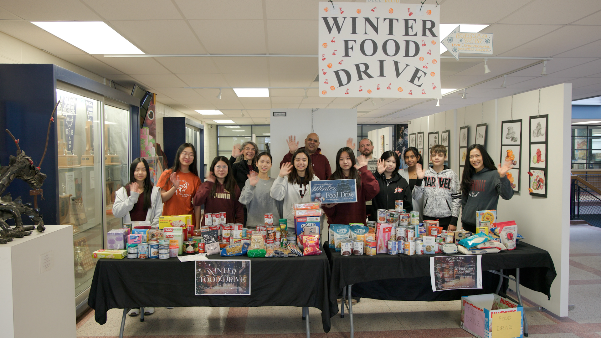 Students stand in front of a table piled with different food items