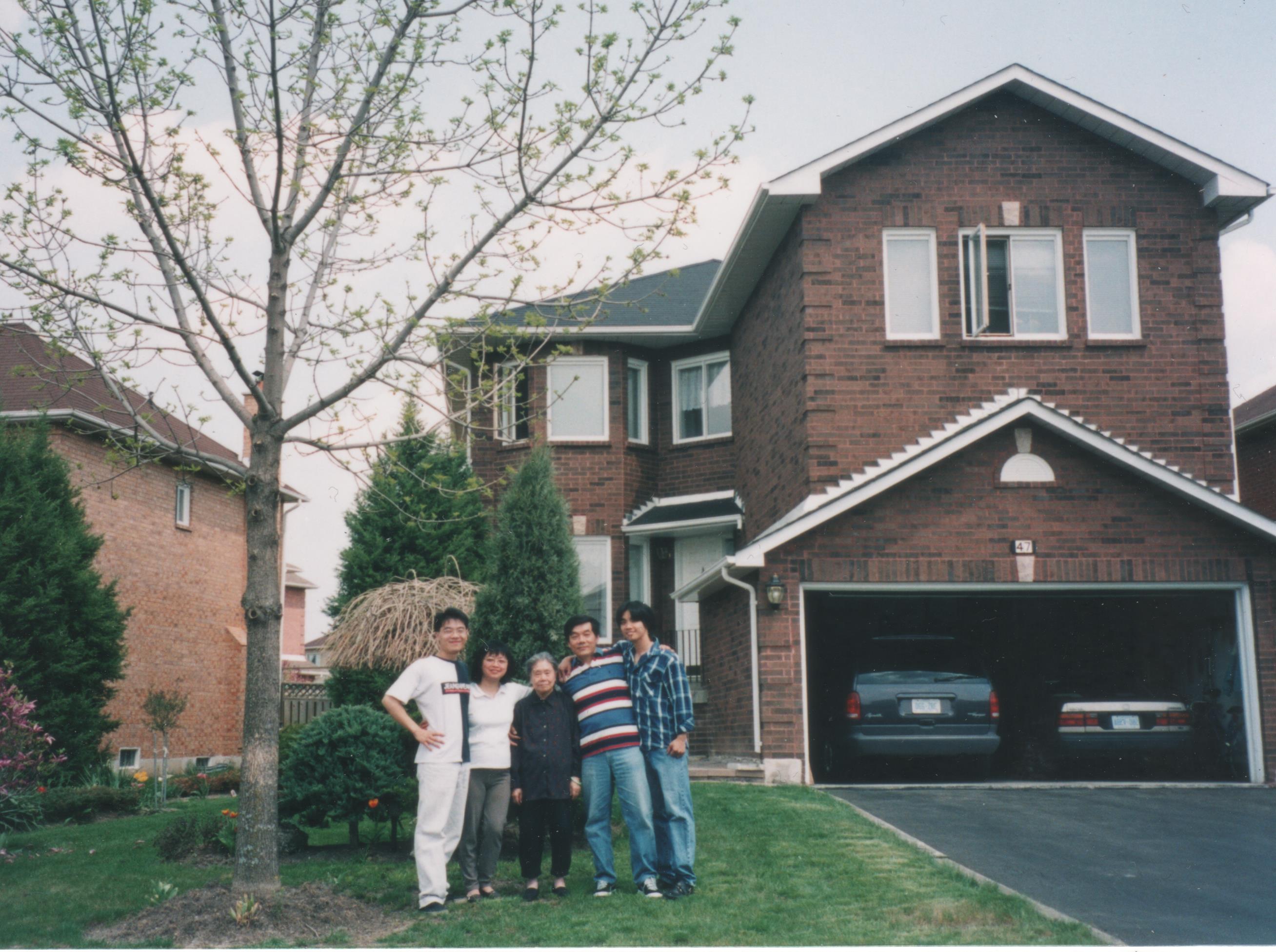 family standing in front of house