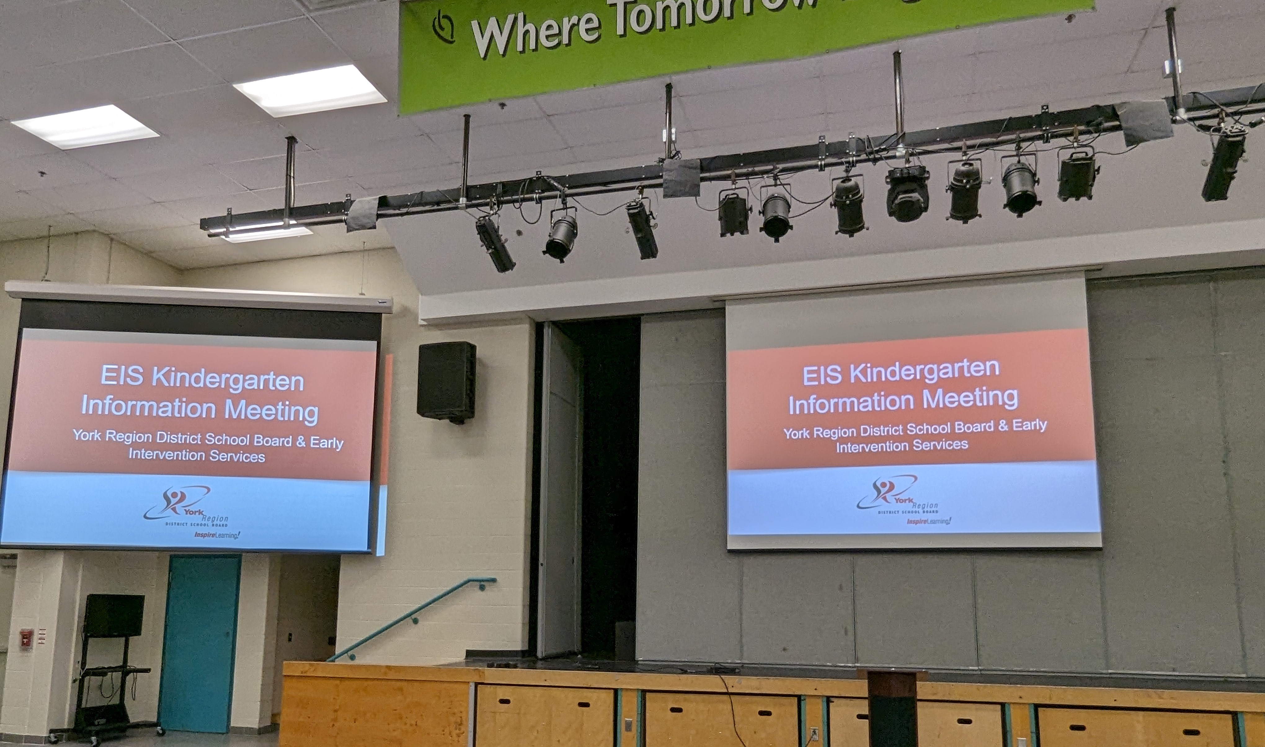 Two screens in the cafeteria at Richmond Green SS that display the text EIS Kindergarten Information Meeting. York Region District School Board and Early Intervention Services.