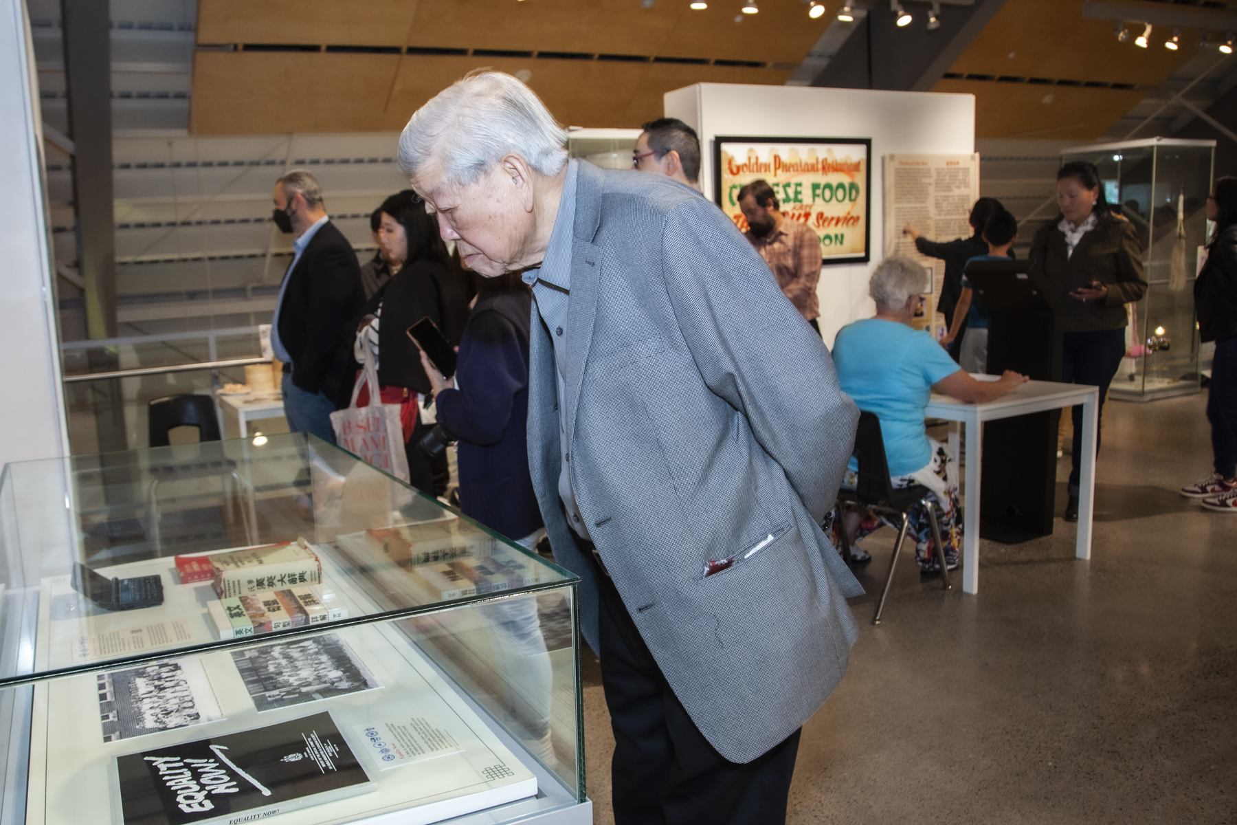 man looking at photographs in display case
