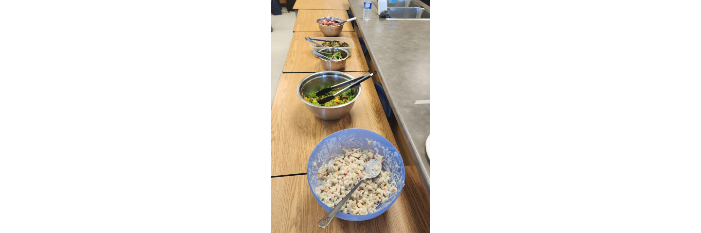 Five bowls of different salads spread out across 4 desks
