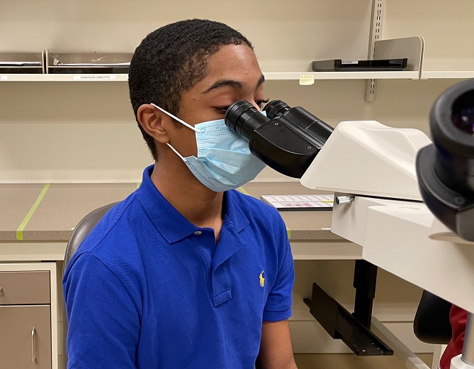 Student looking into microscope