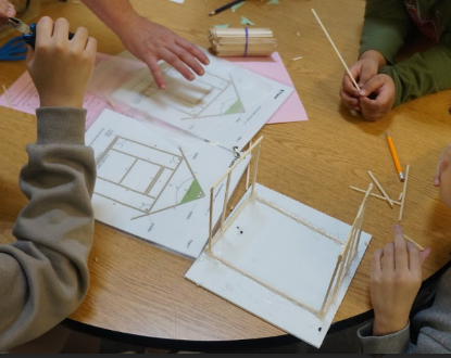 Students building with sticks at a table