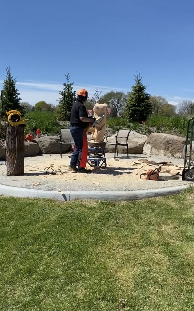 Wood carver carving a bear statue