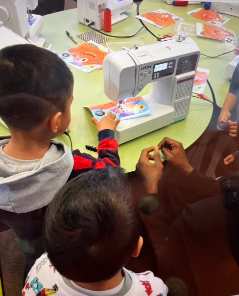 Students with a sewing machine