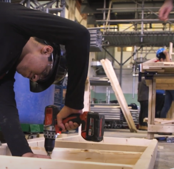 Student drilling into wooden frame