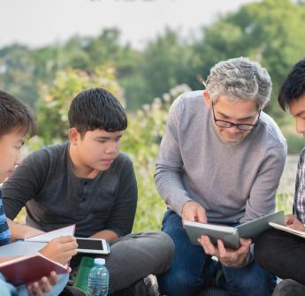secondary students teacher studying book outside