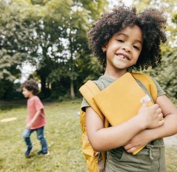 student holding notebook outdoors