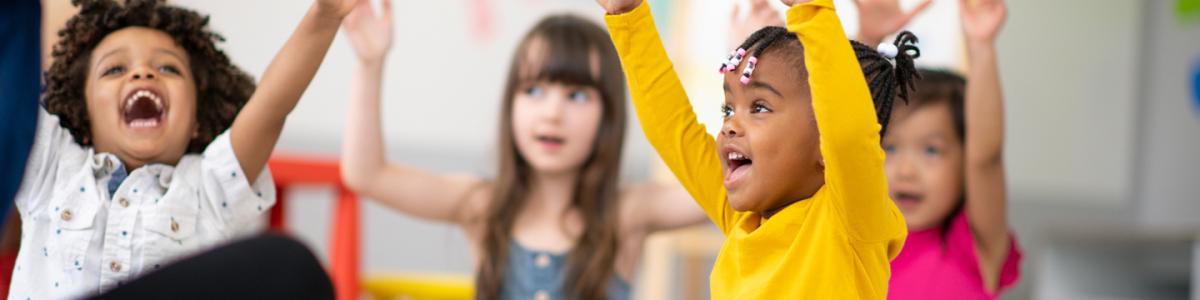 Young students with hands raised