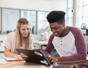 Students looking at laptop