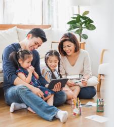 Parents looking at tablet with children