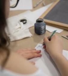 Student writing with ink on paper Student writing with ink on paper