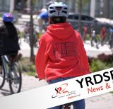 Two students riding bikes toward a school bike rack