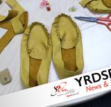 Almost finished moccasins on table with pair of scissors 