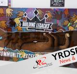 Mural with colour images of hands and the words "Building Legacies"