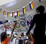 students hanging up pride welcome banner