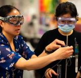 Teacher holds test tube while student observes