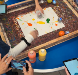 students using robot balls to paint on a canvas