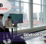 Students present in front of a large wall of  windows