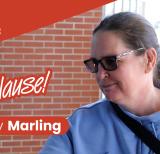 Woman wearing sunglasses and blue sweatshirt enters a school building. Text reads Applause: Abby Marling.