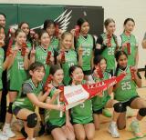 Team of female athletes in green uniforms that say Frechette pose, holding up one finger. They hold a red and white pennant