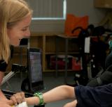 Seated student smiles at adult